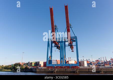 AMBURGO, GERMANIA - 12 AGOSTO 2024: Un'impressionante vista ad angolo basso di due massicce e moderne gru container nel porto di Amburgo Foto Stock