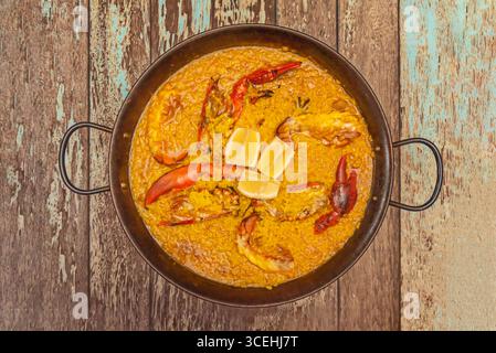Paella di aragosta con crostacei interi come contorno, servita direttamente dalla padella alla tavola Foto Stock