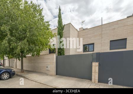 Maestosa residenza unifamiliare con una facciata principale rivestita in marmo bianco e una passerella acciottolata con fioriere integrate Foto Stock