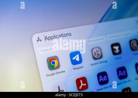 Poznan, Polonia - 15 agosto 2025: Cartella applicazioni su macOS 26, che mostra Google Chrome, Telegram e altri software, con Modern Liquid Glass Foto Stock
