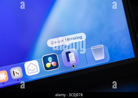 Poznan, Polonia - 15 agosto 2025: Applicazione di mirroring per iPhone, visibile sull'interfaccia macOS 26, esemplifica l'estetica del vetro liquido per un de senza cuciture Foto Stock