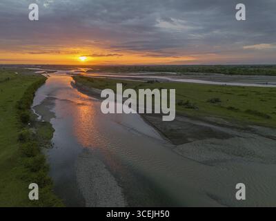 Tramonto impressionante riflesso su un fiume calmo sotto un cielo arancione, vista aerea, Amaghleba, Rioni, regione d'Imereti, Georgia Foto Stock