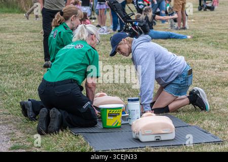 St John Ambulance offre volontari che insegnano o dimostrano la tecnica di rianimazione cardiopolmonare (RCP) salvavita in un evento pubblico, Inghilterra, Regno Unito Foto Stock