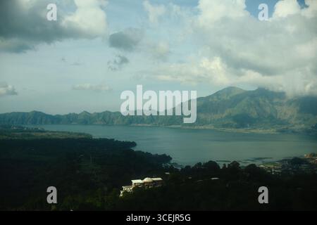 Un pittoresco paesaggio del Lago Batur circondato da lussureggianti montagne verdi Foto Stock
