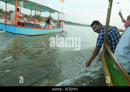 Turisti e locali, donne indigene e uomo in tradizionale abito nazionale. Bellissimo tempio antico a Vrindavan, Uttar Pradesh, India. 8 aprile 2025 Foto Stock