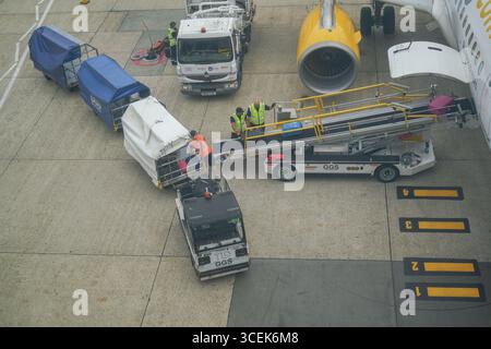 Gatwick, Regno Unito 18 agosto 2025. Portabagagli che scaricano i bagagli dei passeggeri da un aereo all'aeroporto di Gatwick. I gestori dei bagagli rappresentati dall' Unione delle TIC hanno sospeso lo sciopero che avrebbe avuto luogo dal 22 -26 agosto dopo che è stata presentata una nuova offerta di pagamento . Amer Ghazzal/Alamy Live News Foto Stock