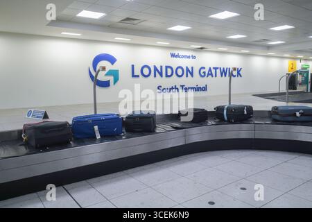 Gatwick, Regno Unito 18 agosto 2025. I bagagli vengono scaricati su un nastro trasportatore presso il terminal sud dell'aeroporto di Gatwick. I gestori dei bagagli rappresentati dall' Unione delle TIC hanno sospeso lo sciopero che avrebbe avuto luogo dal 22 -26 agosto dopo che è stata presentata una nuova offerta di pagamento . Amer Ghazzal/Alamy Live News Foto Stock