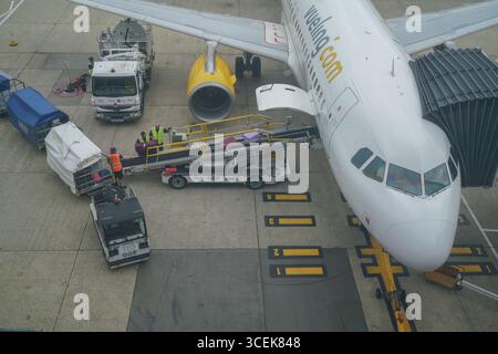 Gatwick, Regno Unito 18 agosto 2025. Portabagagli che scaricano i bagagli dei passeggeri da un aereo all'aeroporto di Gatwick. I gestori dei bagagli rappresentati dall' Unione delle TIC hanno sospeso lo sciopero che avrebbe avuto luogo dal 22 -26 agosto dopo che è stata presentata una nuova offerta di pagamento . Amer Ghazzal/Alamy Live News Foto Stock