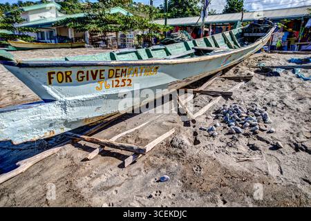 Soufriere, Saint Lucia - 27 dicembre 2015: Una tradizionale barca da pesca in legno si trova sulla spiaggia sabbiosa di Soufriere, Saint Lucia. Foto Stock