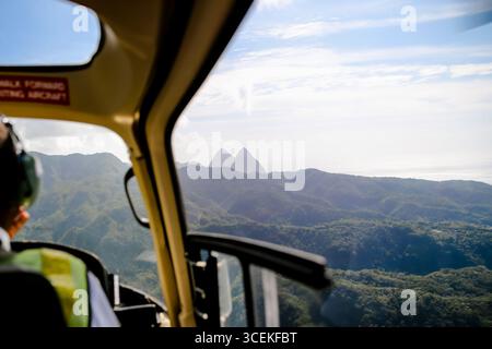 Morgan Bay, Saint Lucia - 22 dicembre 2015: Viste delle lontane montagne Pitons dalla spalla di un pilota di elicottero che sorvola St Lucia Foto Stock