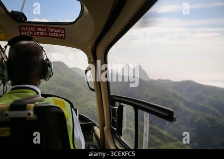 Morgan Bay, Saint Lucia - 22 dicembre 2015: Viste delle lontane montagne Pitons dalla spalla di un pilota di elicottero che sorvola St Lucia Foto Stock