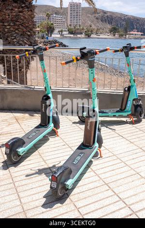 Tre scooter elettrici di fila a Los Cristianos, Tenerife, Canarie. Foto Stock