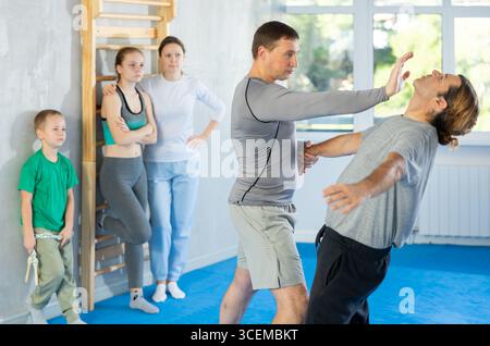 L'uomo in palestra esegue elementi di base del sistema di autodifesa krav maga. Foto Stock