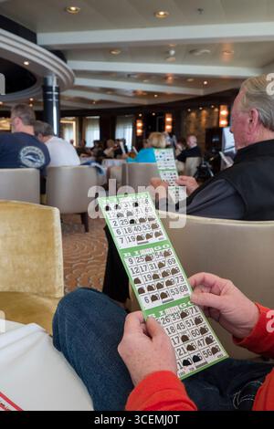 Donna che mantiene la scheda di bingo giocando a bordo del Regent Seven Seas Voyager nave da crociera Foto Stock