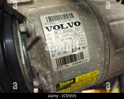 Primo piano dell'etichetta del compressore dell'impianto di climatizzazione Valeo su un ricambio Volvo, che mostra il tipo di refrigerante (HFC-134a) e i dettagli del numero di serie Foto Stock