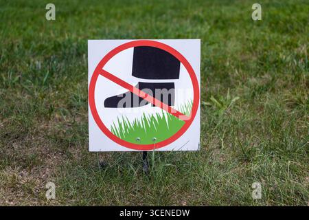 Cartello indicante il divieto di camminare sull'erba in un'area verde pubblica Foto Stock