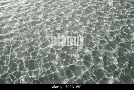 Ombre danzanti e luci della scintillante superficie d'acqua della piscina Foto Stock