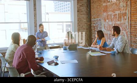 Uomo d'affari che conduce una riunione con i colleghi nella sala riunioni Foto Stock