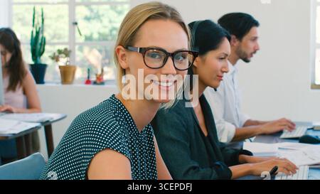 Donna d'affari che lavora in un team multiculturale che indossa cuffie nel servizio clienti Foto Stock