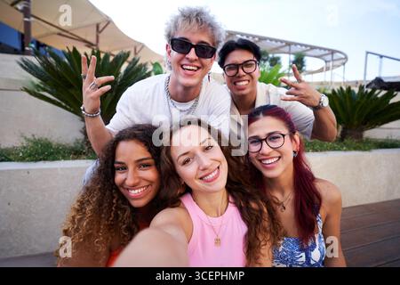 Gruppo di giovani amici felici che si fanno un selfie all'aperto. Foto Stock