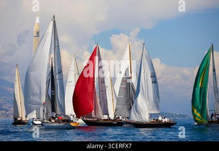 Yacht a vela classici con colorate Spinnaker che gareggiano in una vivace regata in un giorno di sole Foto Stock