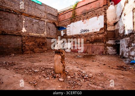 Interni esposti di un edificio demolito a Marrakech, Marocco. Pareti, graffiti e macerie sbriciolano raccontano una storia di distruzione, degrado e artrosi Foto Stock