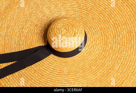 Primo piano di un cappello di paglia a tesa larga con un dettaglio nero del nastro, ideale per proteggere il sole durante i mesi estivi Foto Stock