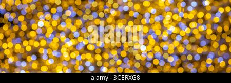 Luci bokeh gialle e blu che creano uno splendido sfondo astratto, perfetto per festeggiamenti e vacanze Foto Stock