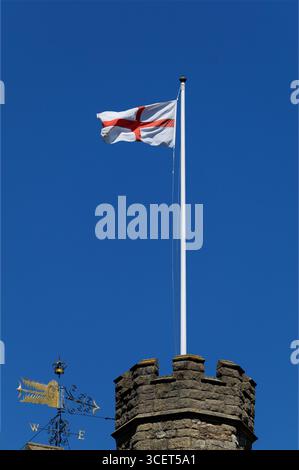 La bandiera inglese che sventola sulla torre della St Marys Church, Twickenham, Londra, contro un cielo azzurro. Foto Stock