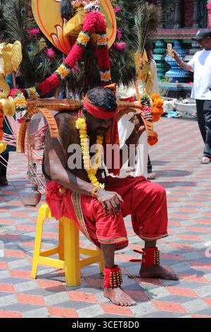 Devoto indù esausto con ganci rituali che gli perforano la schiena durante il festival Thaipusam alle grotte Batu, Kuala Lumpur, Malaysia, 31 gennaio 2025 Foto Stock