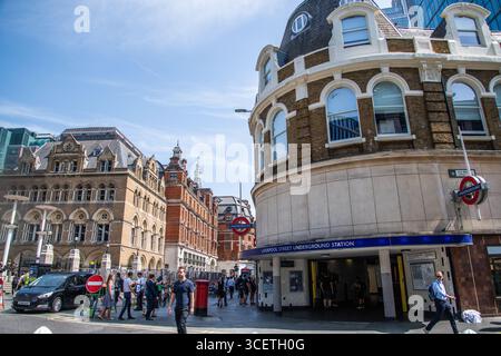Ingresso alla stazione della metropolitana Liverpool Street di Londra sulla Old Broad Street, vivace scena cittadina nel cuore di Londra. Foto Stock