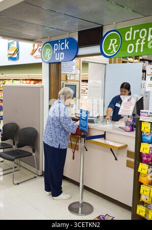 Anziana donna caucasica ottenendo il suo prescrizione farmaci da farmacia in un negozio di alimentari, Honolulu Oahu, Hawaii, STATI UNITI D'AMERICA Foto Stock