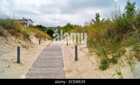 Passerella in legno attraverso le dune dell'isola di Usedom, sentiero sabbioso che conduce verso il Mar Baltico. Foto Stock