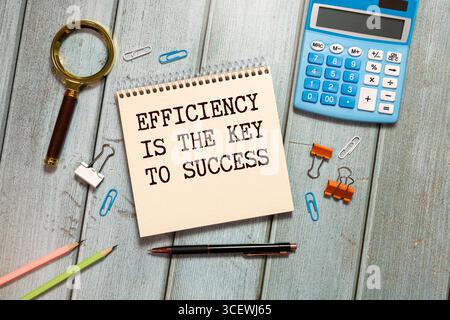 Un notebook ordinato con testo "OKR (Objectives and Key Results) Framework" con un adesivo, posizionato su una scrivania. Foto Stock