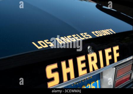 Vista ravvicinata del bagagliaio posteriore di un veicolo dello sceriffo della contea di Los Angeles, che mostra la scritta ufficiale dello sceriffo e la targa parziale. Foto Stock