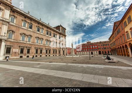 Modena, italia 20 agosto 2025: Palazzo ducale e piazza roma con monumento a ciro menotti sotto il cielo nuvoloso a modena, italia Foto Stock