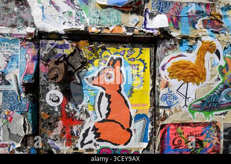 Porte coperte da poster in pasta di grano Street art, Fournier Street, Londra, Regno Unito. 12 giugno 2025 Foto Stock