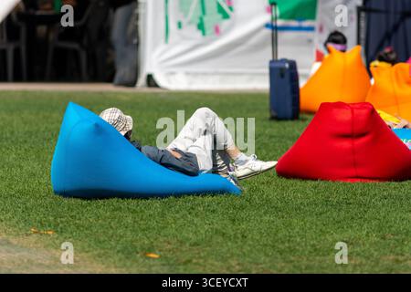 Persone che si rilassano sui sacchi di fagioli colorati in Seoul Plaza, situato di fronte al municipio di Seoul a Taepyeongno, quartiere Jung, Seoul, Corea del Sud al 1° ottobre Foto Stock
