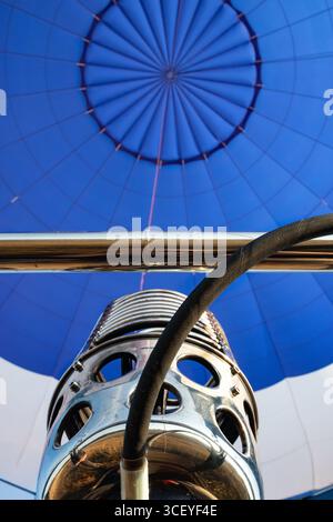 Vista ravvicinata della parte metallica del motore e del tubo che eroga gas per riempire il palloncino con aria calda per volare nell'aria Foto Stock
