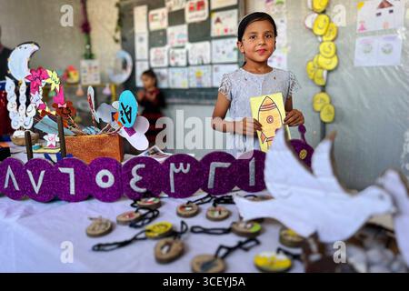 Insegnanti palestinesi organizzano una mostra educativa per i bambini all'interno di una tenda di apprendimento insegnanti palestinesi organizzano una mostra educativa per i bambini all'interno di una tenda di apprendimento nel campo di Nuseirat, nella Striscia di Gaza, sotto il titolo Bright Imprints . La mostra riflette un anno di apprendimento e resilienza, mostrando opere educative e artistiche che incarnano speranza e determinazione per la vita, in mezzo al crollo del sistema educativo e alla distruzione della maggior parte delle scuole a causa della guerra israeliana in corso a Gaza, 20 agosto 2025. Foto di Belal Abu Amer apaimages Nusairat Striscia di Gaza Palestina Foto Stock
