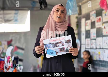Insegnanti palestinesi organizzano una mostra educativa per i bambini all'interno di una tenda di apprendimento insegnanti palestinesi organizzano una mostra educativa per i bambini all'interno di una tenda di apprendimento nel campo di Nuseirat, nella Striscia di Gaza, sotto il titolo Bright Imprints . La mostra riflette un anno di apprendimento e resilienza, mostrando opere educative e artistiche che incarnano speranza e determinazione per la vita, in mezzo al crollo del sistema educativo e alla distruzione della maggior parte delle scuole a causa della guerra israeliana in corso a Gaza, 20 agosto 2025. Foto di Belal Abu Amer apaimages Nusairat Striscia di Gaza Palestina Foto Stock