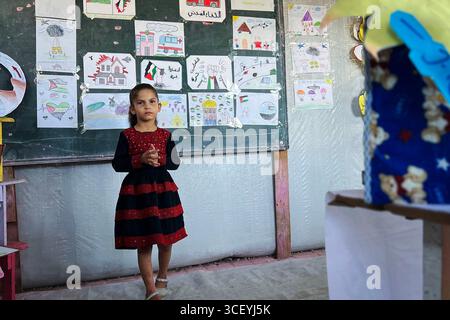Insegnanti palestinesi organizzano una mostra educativa per i bambini all'interno di una tenda di apprendimento insegnanti palestinesi organizzano una mostra educativa per i bambini all'interno di una tenda di apprendimento nel campo di Nuseirat, nella Striscia di Gaza, sotto il titolo Bright Imprints . La mostra riflette un anno di apprendimento e resilienza, mostrando opere educative e artistiche che incarnano speranza e determinazione per la vita, in mezzo al crollo del sistema educativo e alla distruzione della maggior parte delle scuole a causa della guerra israeliana in corso a Gaza, 20 agosto 2025. Foto di Belal Abu Amer apaimages Nusairat Striscia di Gaza Palestina Foto Stock