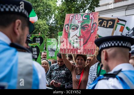 Londra, Regno Unito. 20 agosto 2025. (NOTA DELL'EDITORE: L'immagine raffigura la profanità) il protestatore pro-palestinese regge un cartello anti-Netanyahu fuori dalla Corte dei magistrati di Westminster. Mo Chara era di nuovo in tribunale a Londra per un'accusa di terrore. E' accusato di aver esposto una bandiera a sostegno di Hezbollah in un concerto a Londra nel novembre dello scorso anno. Molte centinaia di manifestanti filo-palestinesi erano presenti per opporsi all'accusa. Credito: SOPA Images Limited/Alamy Live News Foto Stock