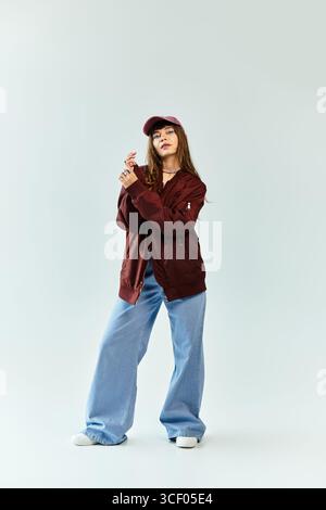 Una giovane donna elegante trasuda fiducia nel suo abbigliamento alla moda e confortevole. Foto Stock