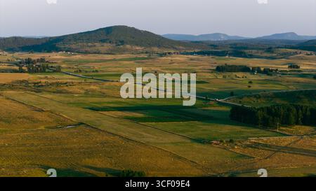 Ampia vista sull'altopiano di Glasinac con sfondo montano e campi agricoli a motivi geometrici Foto Stock