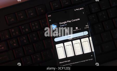 Smartphone che mostra la pagina di installazione dell'app Google Play Console con la tastiera in background Foto Stock