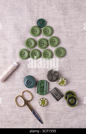 Albero di Natale realizzato con bottoni verdi su tessuto di lino. Fase 1 Foto Stock