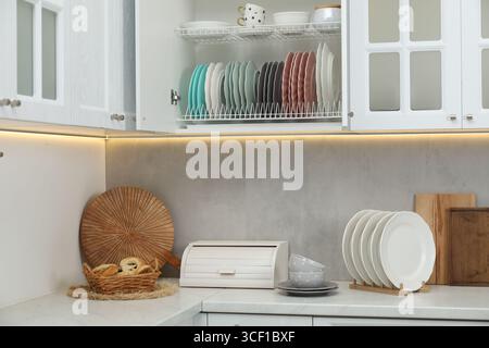 Lavare stoviglie e tazze sui ripiani degli armadi interni Foto Stock