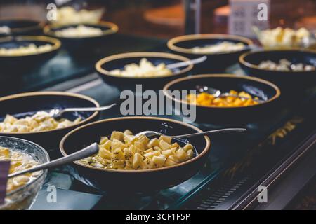 Caratterizzato da un variopinto assortimento di formaggi e frutta tritata elegantemente esposti in ciotole su un tavolo a buffet, offre agli ospiti una selezione allettante Foto Stock