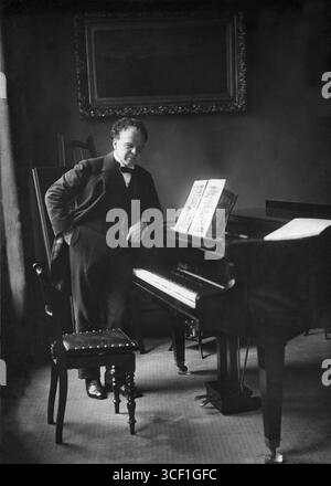 Il pianista e compositore scozzese Frédéric Lamond (1868-1948), uno degli ultimi studenti di Franz Liszt, è raffigurato appoggiato contro un pianoforte nel 1918. Fu anche insegnante al conservatorio dell'Aia. Foto Stock